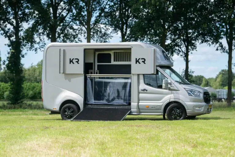 Zijkant van paardenvrachtwagen met opengeklapte klep en luiken, interieur van Horsetruck Wilp vrachtwagen zichtbaar